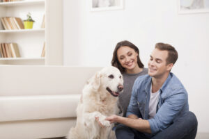 Cheerful family is playing with pretty puppy