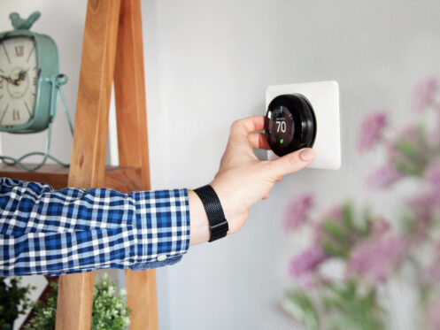 Homeowner adjusting thermostat